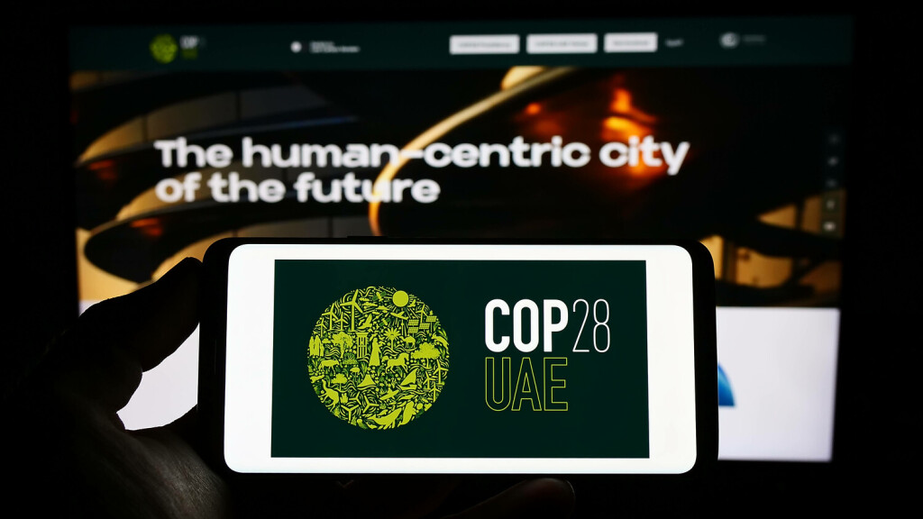 Person holding mobile phone with logo of UN climate change conference COP28 Dubai on screen. Stuttgart, Germany - 03-25-2023: Person holding mobile phone with logo of UN climate change conference COP28 Dubai on screen in front of web page. Focus on phone display. Copyright: xZoonar.com/TimonxSchneiderx 20081766