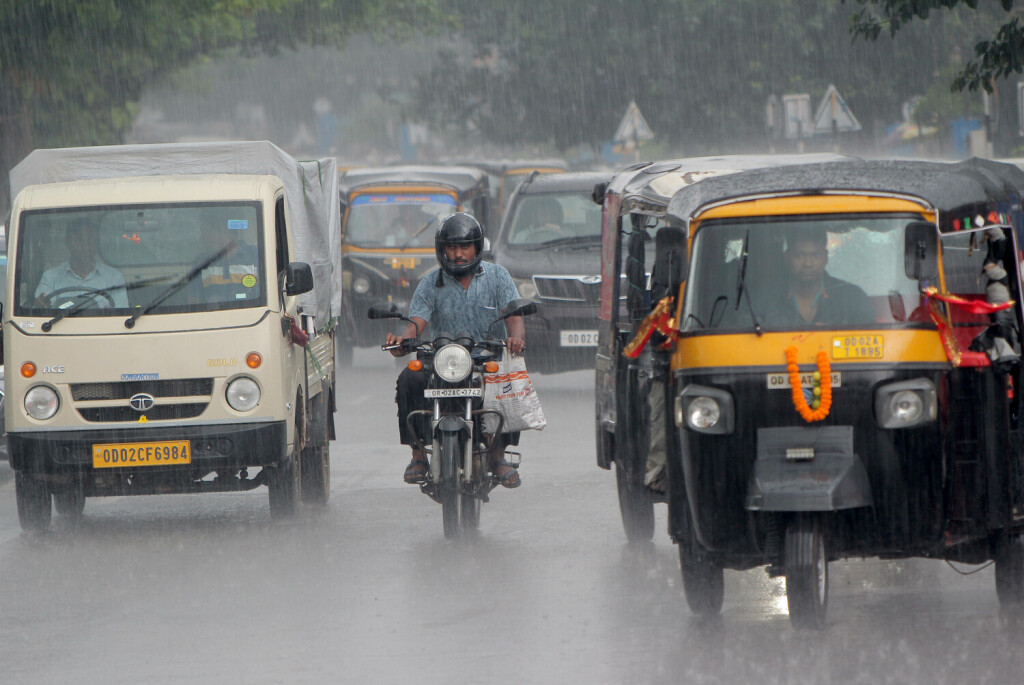 Pendlerverkehr an einem regnerischen Tag in Bhubaneswar, Indien